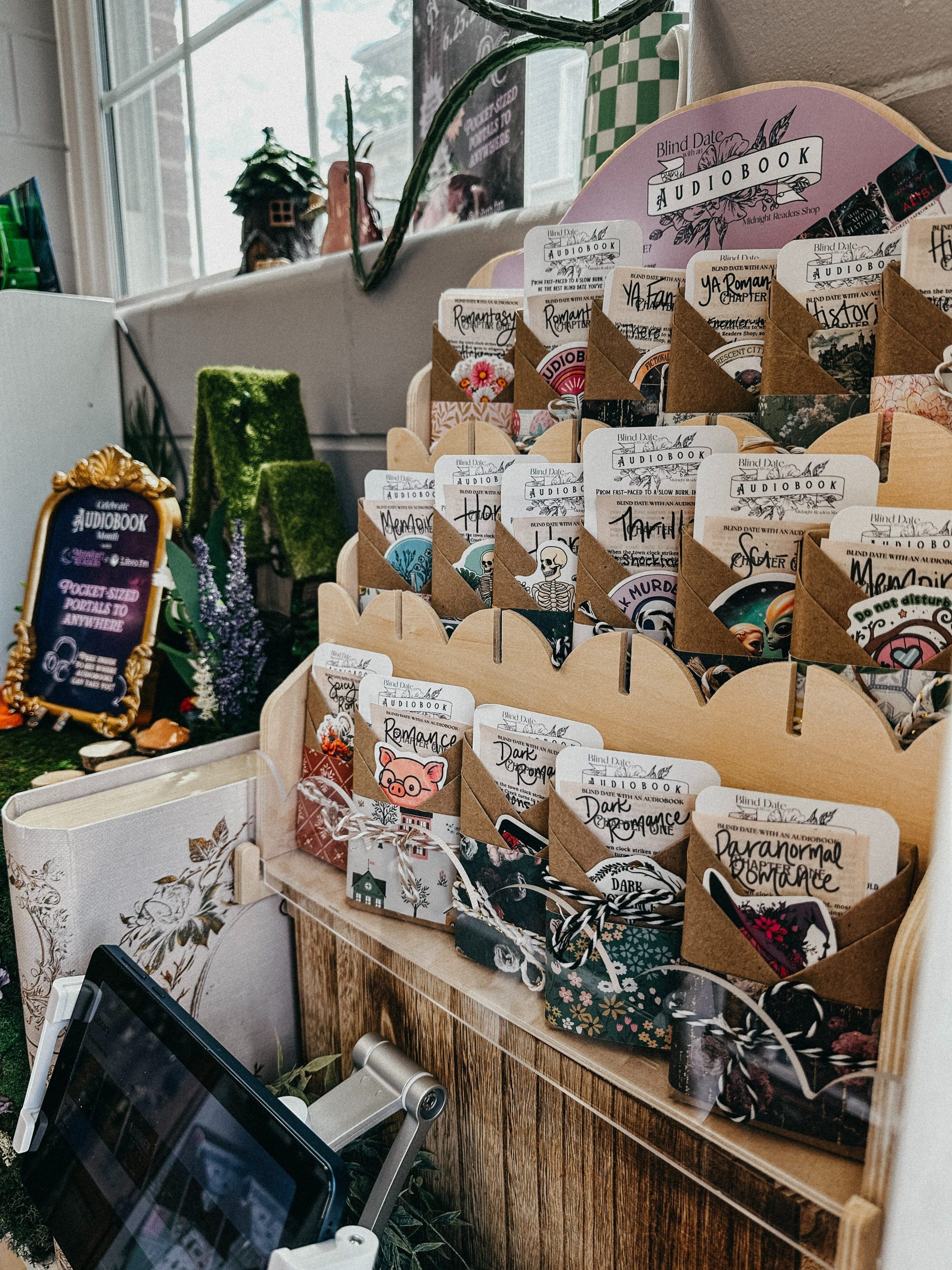 Audiobook display featuring a "blind date with an audiobook" shelf, with audiobook picks wrapped like letters and a tablet for browsing.