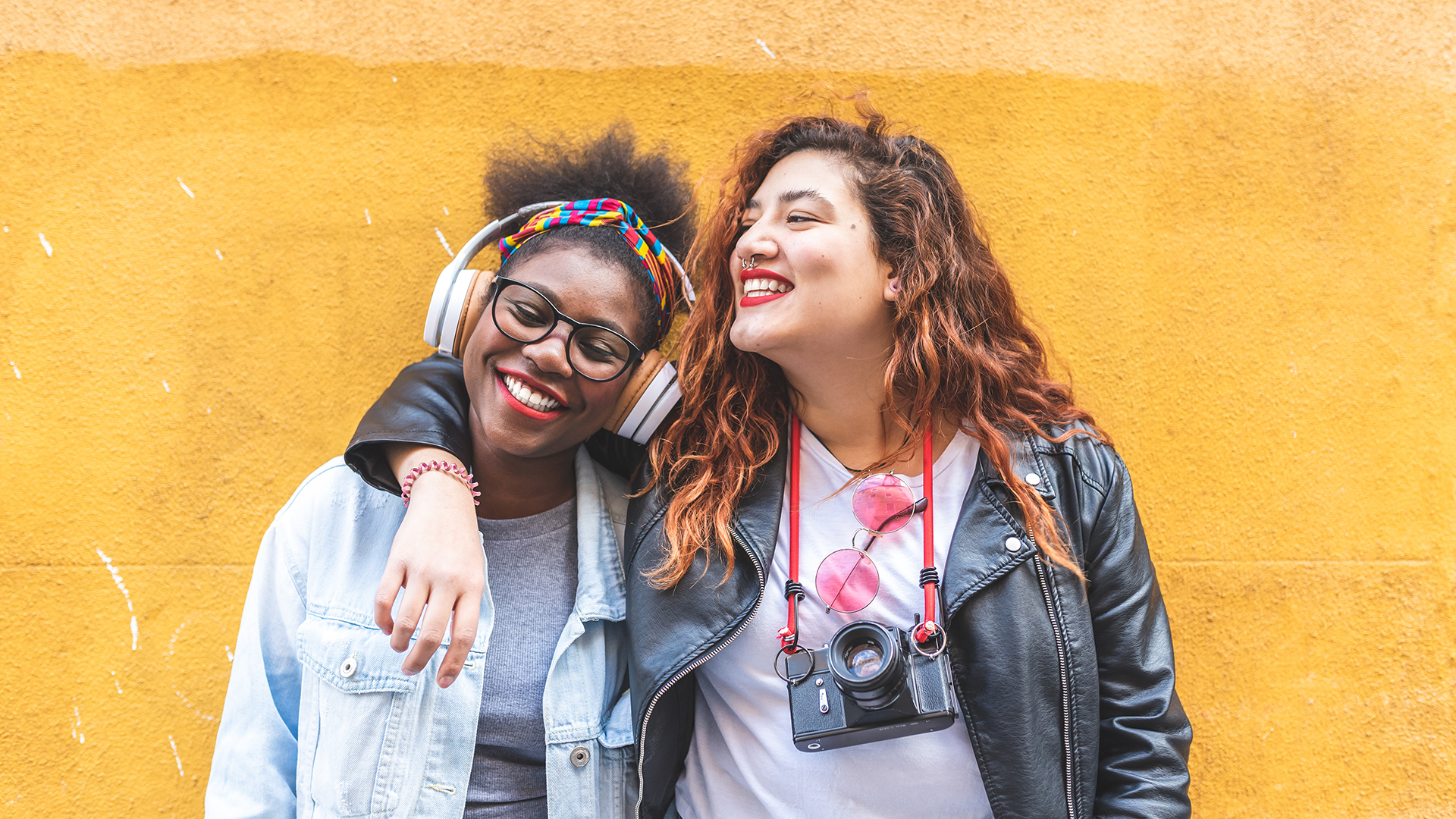 Two individuals hugging, with headphones