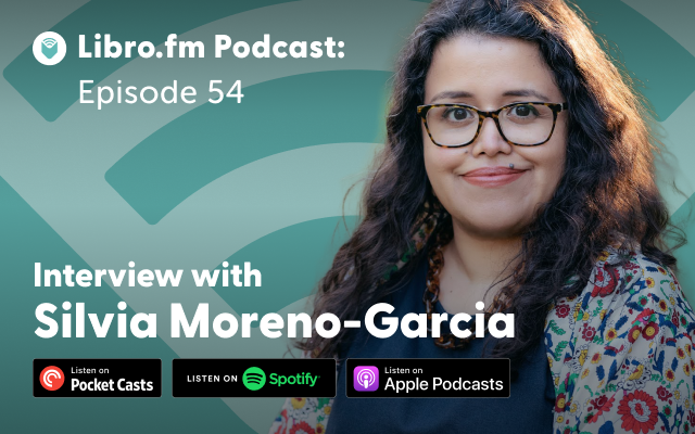 Author Silvia Moreno-Garcia smiles in front of a blue background.