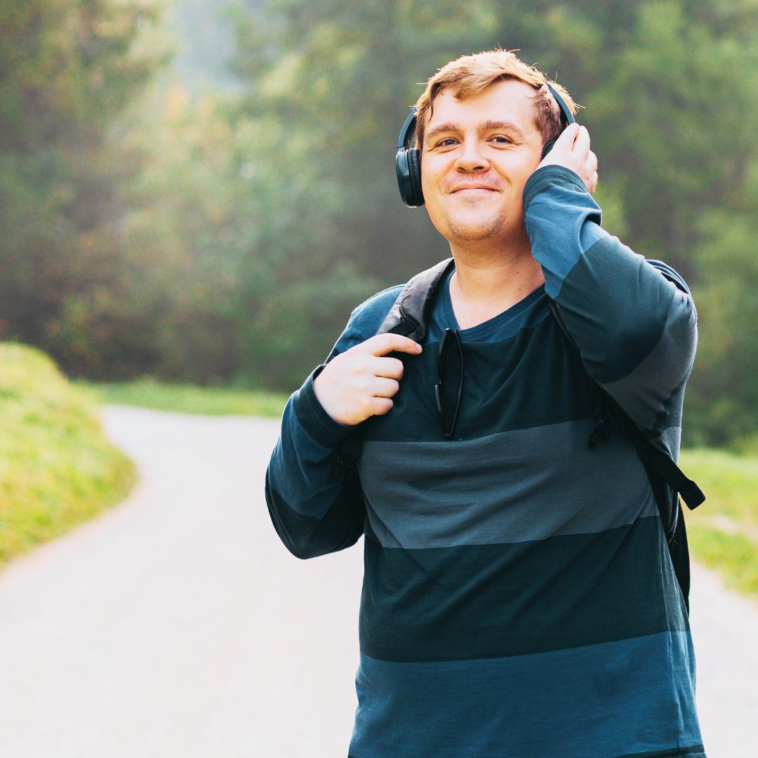 An individual is outside with headphones on.