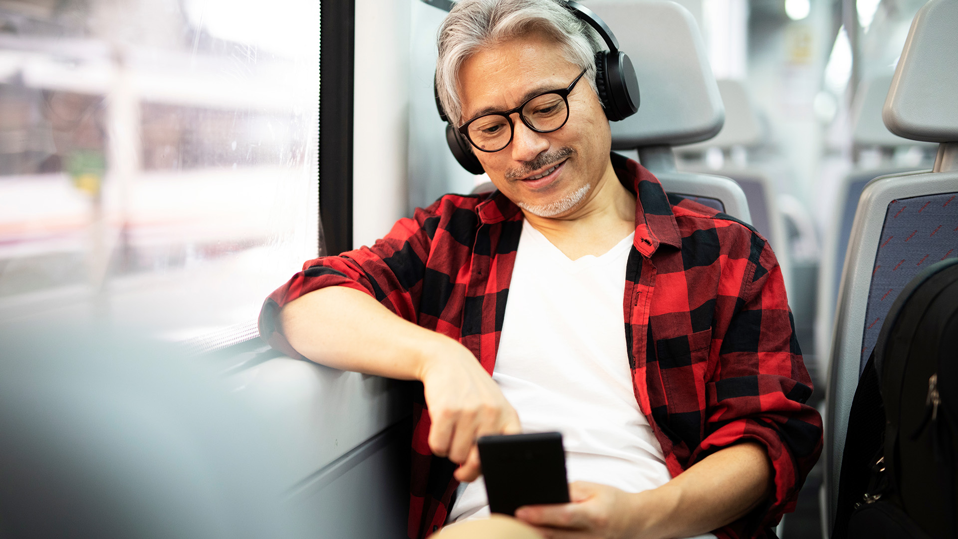 An individual with headphones on, on public transportation